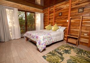 een slaapkamer met een bed en een groot raam bij Cabañas Los Jobos in Villarreal