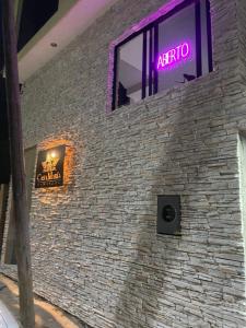 a brick wall with a neon sign in a window at Hotel Casa María Tamasopo in Tamasopo