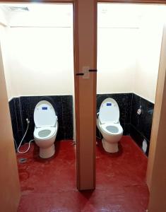 a bathroom with two toilets in a room at Footprints Hostel in Coron
