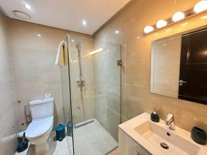 a bathroom with a shower and a toilet and a sink at Greeny view in cosy 3BDR - downtown near train / tram in Casablanca