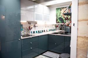 uma cozinha com armários azuis e um lavatório em Pretty house - near botanical garden em Bordéus