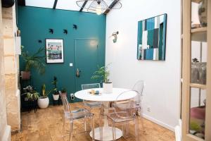 a dining room with a white table and chairs at Pretty house - near botanical garden in Bordeaux