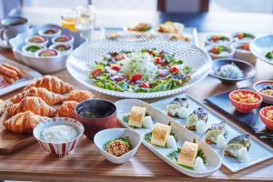a table topped with plates of food and bowls of food at サザンシティホテル in Nankoku