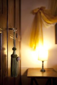 una frusta appesa a una porta accanto a una lampada di Residenza D'epoca San Crispino ad Assisi
