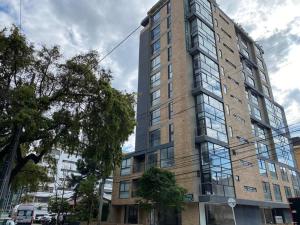 un edificio alto en una calle de la ciudad con en Unicentro Harmony Flats 2 Hab, en Bogotá