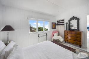 1 dormitorio con cama, tocador y espejo en Cape Cottage, en Cape Bridgewater