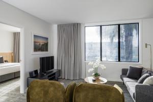 a living room with a couch and a tv at Quest Mt Maunganui in Mount Maunganui