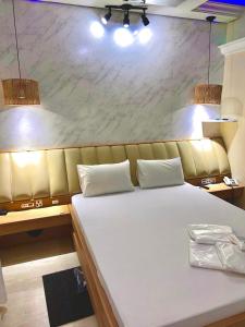 a large white bed in a room with lights at Tennessee Motel ltda in Bragança Paulista