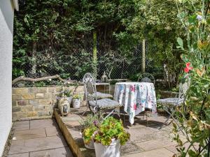 a patio with two chairs and a table with flowers at Green Acres in Nidd