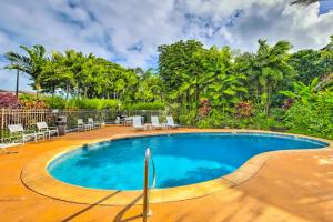 a swimming pool in a resort with chairs and trees at Condos in Kapa'a Sands in Kapaa