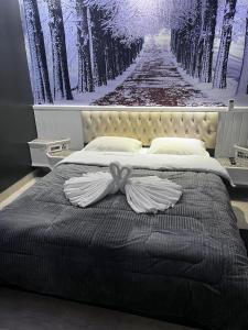a bedroom with a bed with a picture of a forest at Tennessee Motel ltda in Bragança Paulista