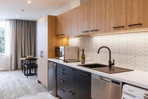 a kitchen with a sink and a microwave at Quest Mt Maunganui in Mount Maunganui
