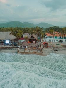 una playa con un grupo de casas y el océano en Praba Hostel en Palomino