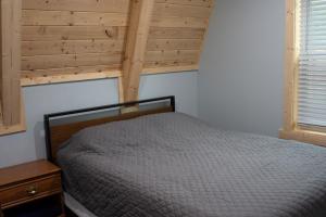 - une chambre avec un lit et un plafond en bois dans l'établissement Nature's Nest, à Au Gres