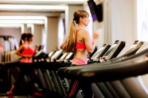 a woman running on a treadmill in a gym at Madrid Marriott Auditorium Hotel & Conference Center in Madrid