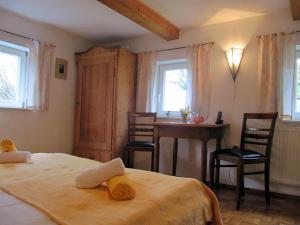 a bedroom with a bed and a table and chairs at Landgasthaus Schwarzbachtal in Lohsdorf