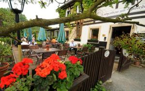 a restaurant with red flowers and people sitting at tables at Landgasthaus Schwarzbachtal in Lohsdorf