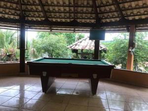a pool table in the middle of a room with windows at Sítio Santa Terezinha in Divinópolis
