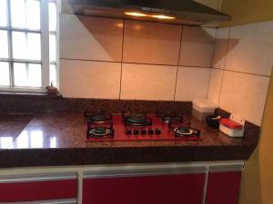 a red stove top oven in a kitchen at Sítio Santa Terezinha in Divinópolis