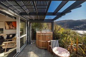 a patio with a hot tub and two chairs on it at Queenstown Hot Tub Apartment in Frankton Wharf