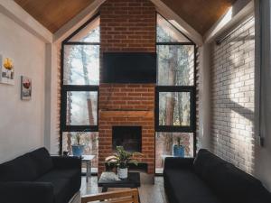 a living room with a brick fireplace and black couches at Bosquecielo in Huasca de Ocampo