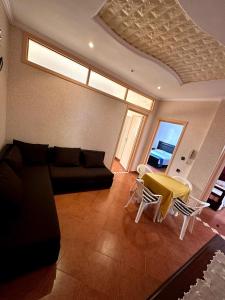 a living room with a couch and a table at Spacieux appartement familial in Agadir