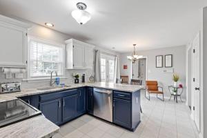 a kitchen with blue cabinets and a dining room at The Safari House: Where Adventure & Comfort Awaits in Richmond