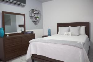 een slaapkamer met een bed, een dressoir en een spiegel bij Blu Lime Apartments in San Juan