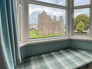 a window seat with a view of a castle at Cochrane House in Kirkcudbright