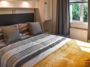 a bedroom with a large bed with a window at Meadow View Van - Uk44667 in Neatishead