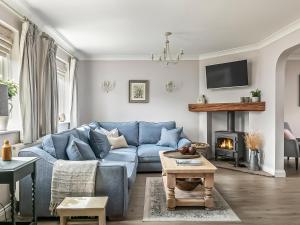 sala de estar con sofá azul y chimenea en The Cherry Tree en Thorney