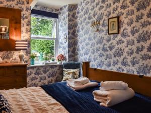 a bedroom with a bed with towels on it at Corner Cottage in Bowness-on-Windermere