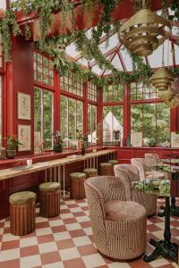 a restaurant with red walls and chairs and windows at Ember Locke Kensington in London