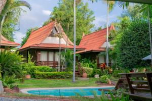 een huis met een oranje dak en een zwembad bij Baan Duangkaew Resort in Hua Hin