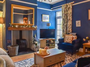 a living room with blue walls and a fireplace at Corner Cottage in Bowness-on-Windermere
