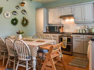 a kitchen with a table and chairs and a stove at Corner Cottage in Bowness-on-Windermere