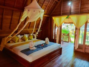 a bedroom with a bed with two mice on it at The Lumbung Tejakula in Tejakula