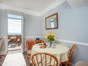 a dining room with a table and chairs and a window at Ocean View, Coastguard Cottages in Dawlish