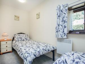 Stokeinteignhead的住宿－The Granary，一间卧室设有两张单人床和一扇窗户。