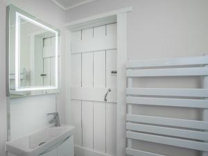 ein weißes Badezimmer mit einem Waschbecken und einem Spiegel in der Unterkunft The Granary in Stokeinteignhead