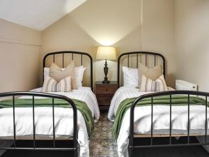 two beds sitting next to each other in a bedroom at Brunswick Holme in Penrith