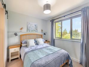 a bedroom with a bed and a window at High Bank in Pontesbury