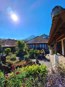 a house with a garden with flowers in front of it at Manigelang Villa in Singaraja