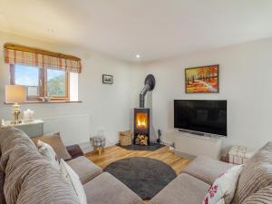 a living room with a couch and a fireplace at The Gallops in Llancarfan