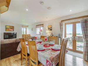 a dining room and living room with a table and chairs at The Gallops in Llancarvan