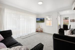 a living room with two couches and a window at Restful Retreat in Tauranga