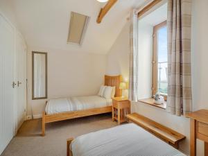 a bedroom with two beds and a window at The Gallops in Llancarvan