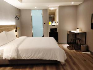 a bedroom with a large white bed and a desk at HINOEN Hotel in Taipei
