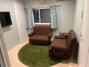 a living room with a couch and a chair at CANAL HOUSE BOSTONS in Niigata