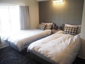 twee bedden naast elkaar in een slaapkamer bij CANAL HOUSE BOSTONS in Niigata